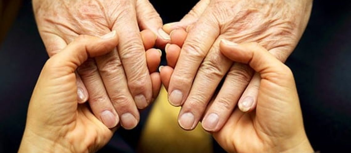 Caregiver and elder holding hands